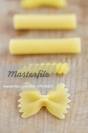 Various types of pasta on a wooden surface