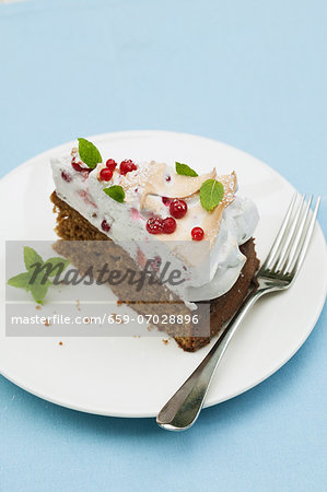 A slice of redcurrant cake with meringue topping and mint