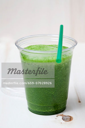 A green smoothie made with spinach, lamb's lettuce, apple, banana and apple mint in a plastic cup