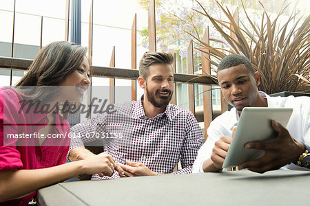 Young business colleagues looking at digital tablet in meeting