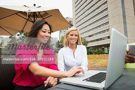 Young business colleagues looking at laptop