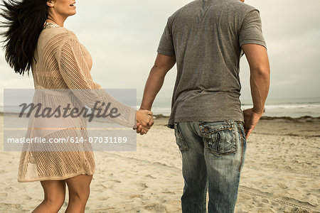 Young couple holding hands on beach Young couple holding hands on beach