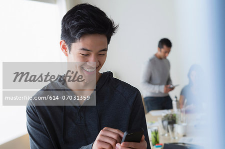 Male office worker texting on mobile phone