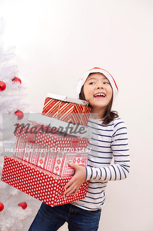 Girl holding Christmas gifts, smiling
