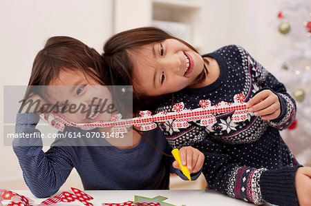 Girls holding Christmas decorations, laughing