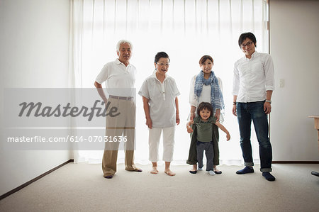 Three generation family standing by window, portrait