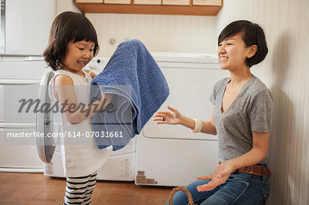 Mother and daughter, girl folding towel