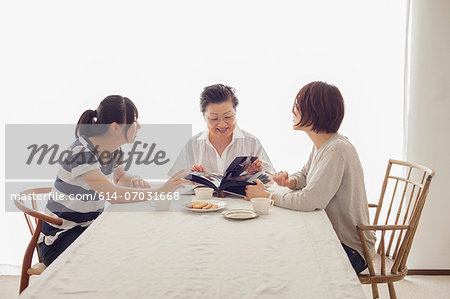 Three generation family looking at photograph album