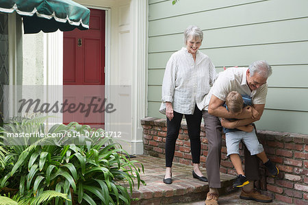 Senior man playing with grandson outside home