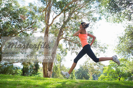 Young woman jogging through park