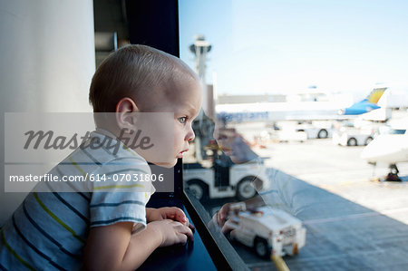 Male toddler looking out of window at Los Angeles airport