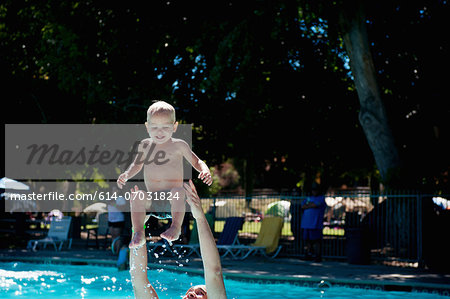 Young male toddler in swimming pool with father