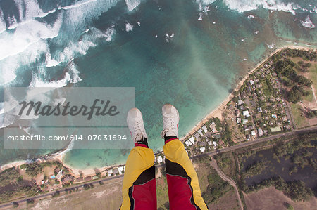 Legs and feet of skydiver above coastline Legs and feet of skydiver above coastline