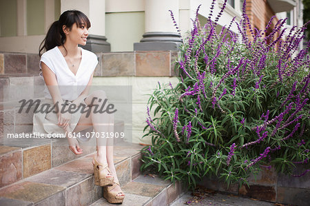 Portrait of young girl sitting on steps at home