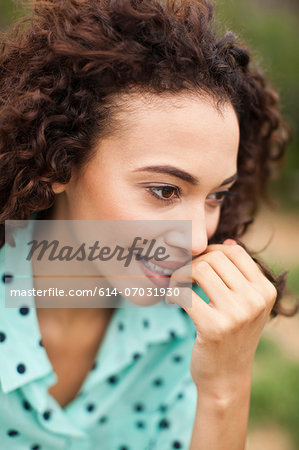 Young woman smiling with hand on chin, close up