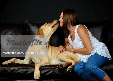 Portrait of labrador retriever and owner on sofa