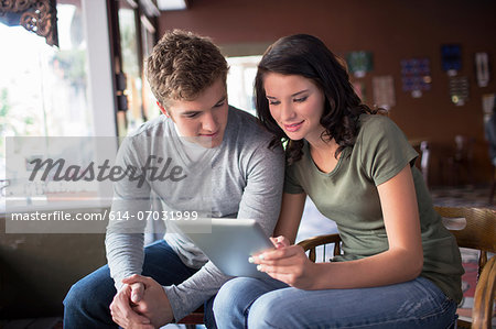 Young couple looking at digital tablet in coffee house Young couple looking at digital tablet in coffee house