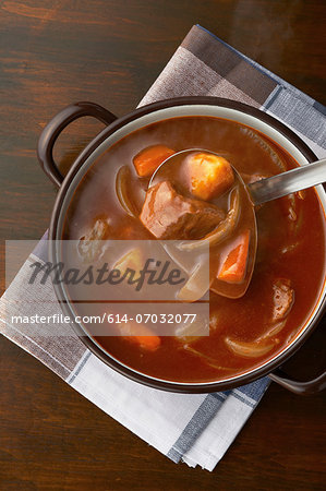 Still life of ladle serving from casserole dish