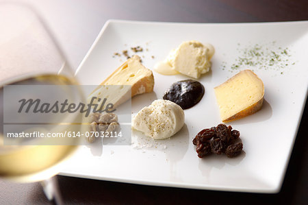 Still life with white wine and selection of cheeses