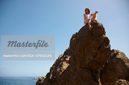 Young woman on top of rocks, Palos Verdes, California, USA