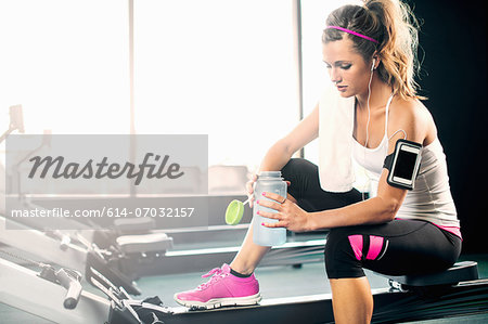 Young woman holding water bottle in gym