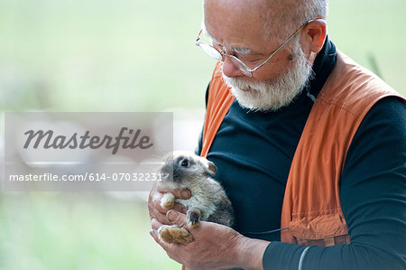 Senior man holding pet rabbit