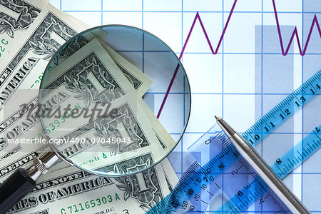 Business concept. Magnifying glass and money on paper background with chart