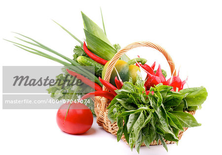 Basket with Various Fresh Raw Vegetables and Greens and Big Red Tomato isolated on white background