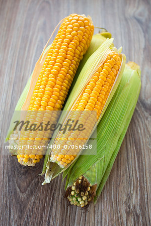 Fresh corn cobs on a wooden table