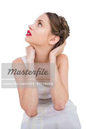 Beautiful woman sitting and looking up against white background