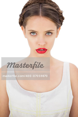 Concentrated model in white dress posing looking at camera on white background