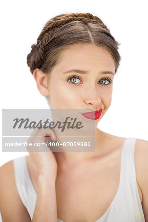 Confused model posing wrinkling her mouth on white background