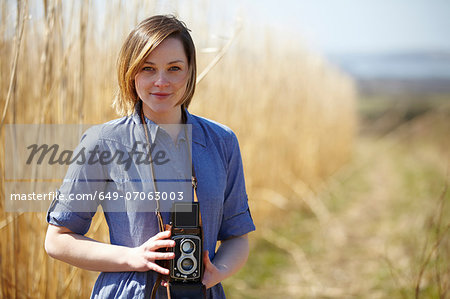 Close up portrait of young woman holding camera