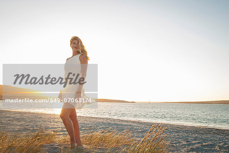 Blond woman posing on beach at dusk, Cape Town, South Africa