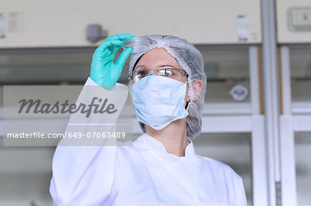 Female scientist examining petri dish