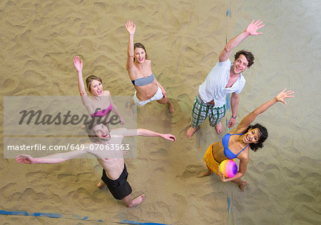 Aerial view of friends waving at indoor beach volleyball