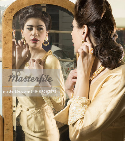 Close up of woman in vintage clothes looking in mirror