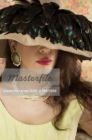 Woman in wide brimmed hat with feathers