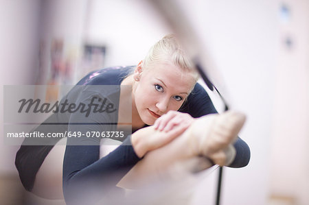 Portrait of female ballerina practicing at the barre