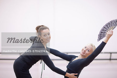 Teacher adjusting ballerinas pose