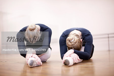 Two ballerinas in pose on studio floor