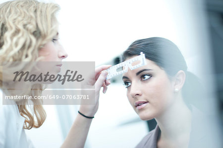 Optician testing patient in eye clinic Optician testing patient in eye clinic