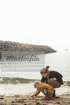 Mother and toddler exploring shoreline