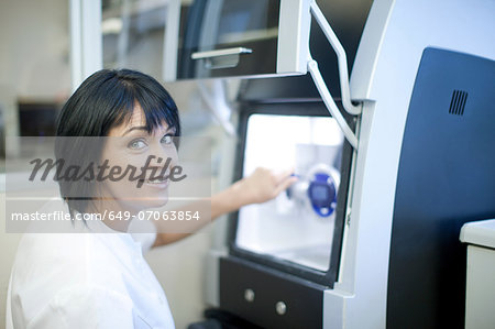 Dental technician using equipment to produce denture