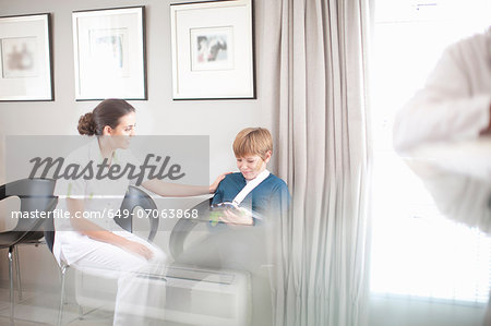 Nurse chatting to young patient in hospital reception