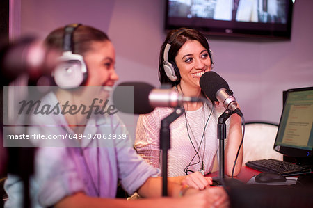 Mid adult and young women broadcasting in recording studio