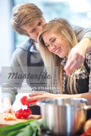 Affectionate young couple preparing meal