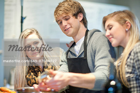 Young adults preparing food in kitchen