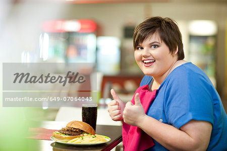 Young woman in cafe with unhealthy meal