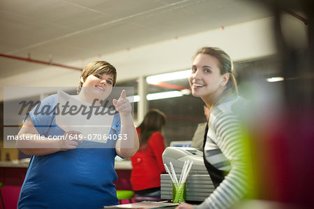 Young woman ordering from menu in cafe